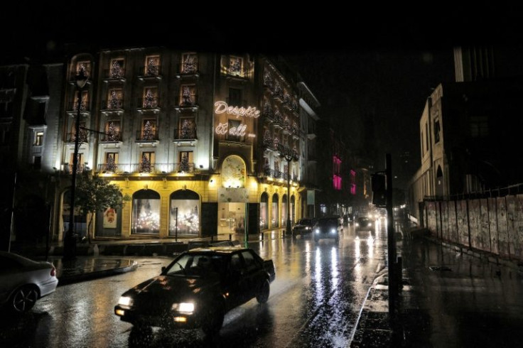 Vehicles drive past closed shops in the darkened Weygand Street in the centre of Lebanon's capital