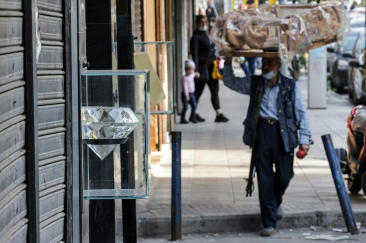 A street vendor walks past shuttered jewellery shops in Beirut's Burj Hammoud neighbourhood on December 14, 2021