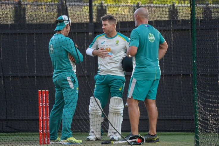 Australia's David Warner (centre) talks to coach Justin Langer (left) about his injury during a practice net session at the Adelaide Oval