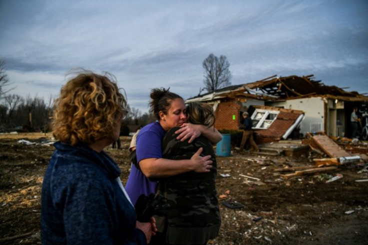 Ginny Watts (C), seen hugging a friend, faces a major challenge this Christmas: keeping the holiday spirit alive for her four-year-old daughter