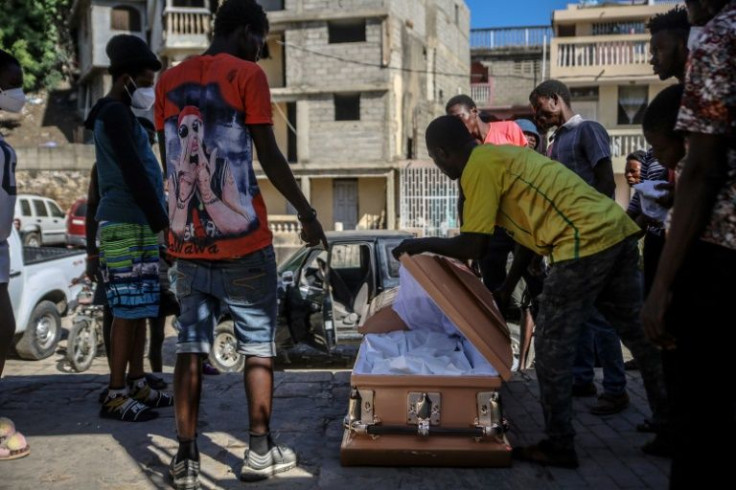Family and community members prepare a victim of the Haitian tanker blast for burial on December 15, 2021, in Cap-Haitien
