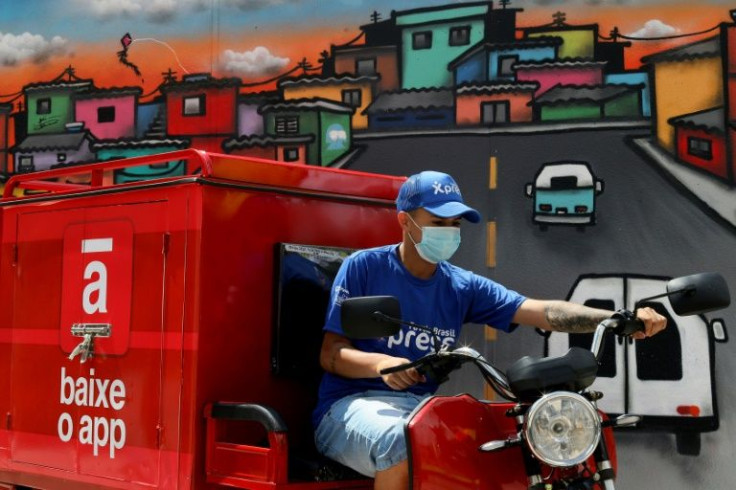 A Favela Xpress employee carries packages to be delivered to residents of the Paraisopolis shantytown, in Sao Paulo, Brazil
