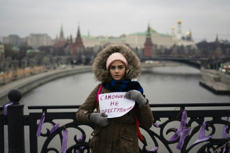 A young woman holds a poster reading "Self-defence is not a crime" in Moscow