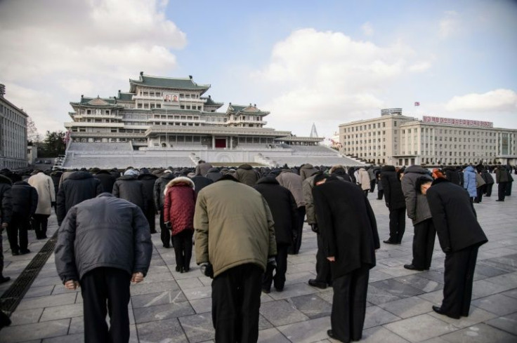 People bow during a three-minute silence to mark the 10th death anniversary of North Korean leader Kim Jong Il