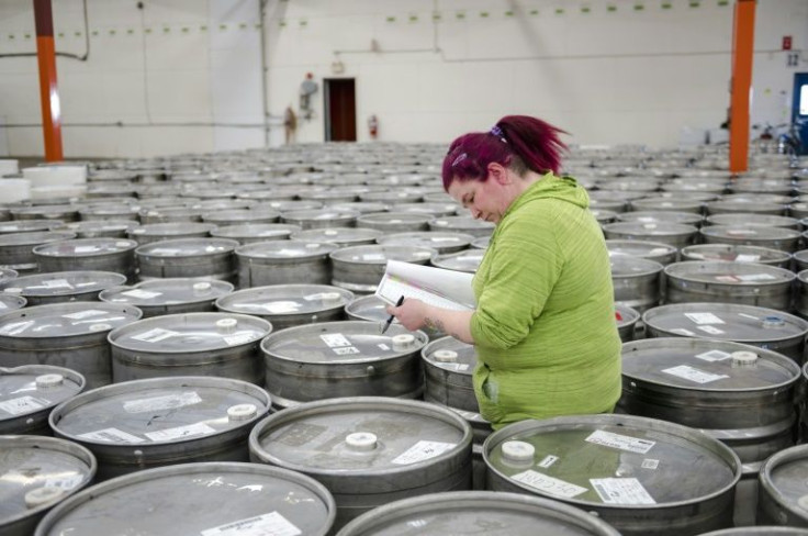 An employee helps identify and sort empty barrels at the Quebec Maple Syrup Producers storage facility in Laurierville, on December 09, 2021
