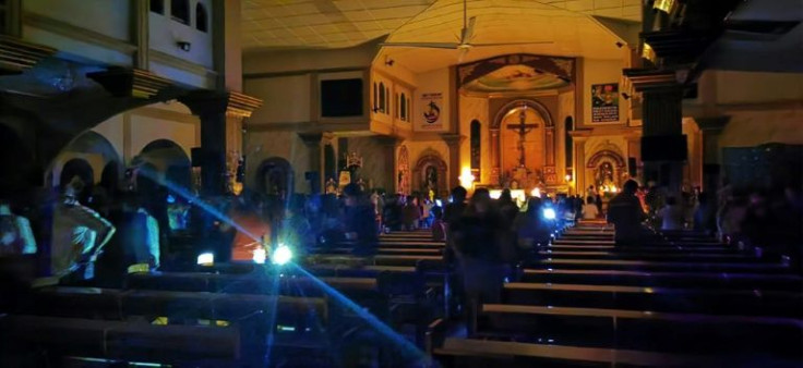 Residents attend a dawn mass without electricity at a church in Surigao City after the typhoon downed power lines
