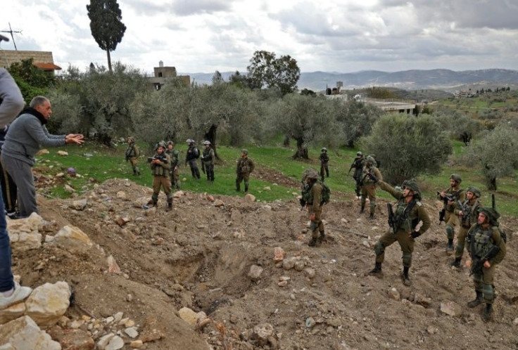 Palestinian residents of the West Bank village of Burqah confront Israeli soldiers on December 17 after reported attacks by Israeli settlers on the village
