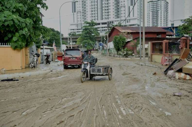 A muddy road after it was hit by flooding in Kuala Lumpur