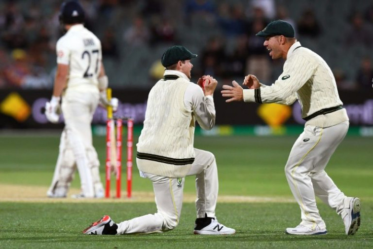 Australia's captain Steve Smith celebrates with teammate David Warner after taking the catch to dismiss England's Rory Burns