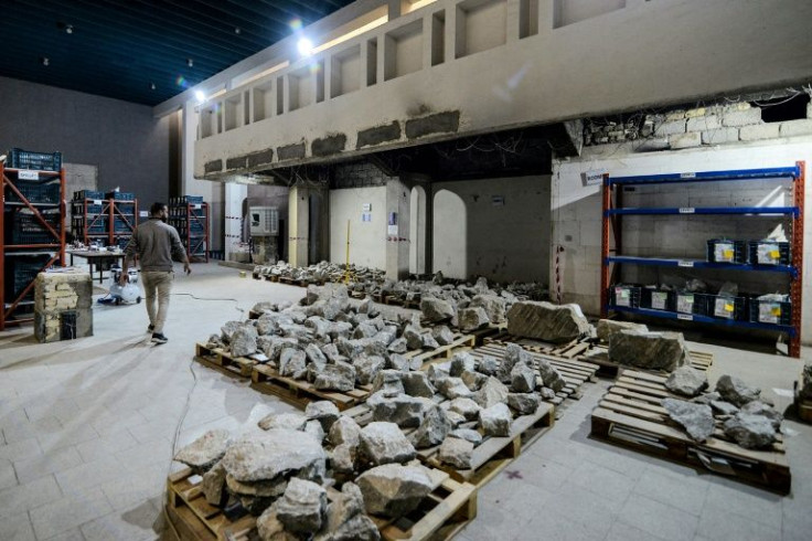 A worker at the Mosul museum walks past artefact fragments to be reconstructed and reassembled