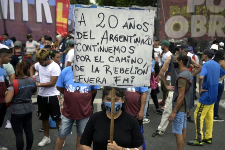 A demonstrator holds a banner denouncing the International Monetary Fund at a protest to mark the 20th anniversary of the 'great crisis'