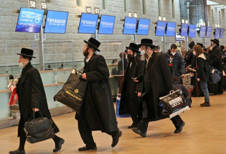 Ultra-Orthodox Jewish travellers hurry to check in for a departing flights from Israel's Ben Gurion Airport