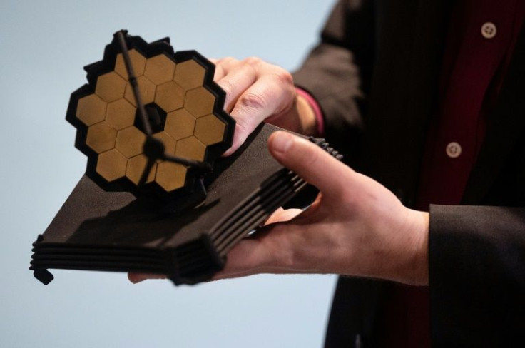The James Webb Space Telescope, seen here in miniature, has a primary mirror that is 21 ft (6.5 m) in diameter and a sun shield the size of a tennis court