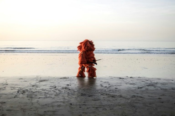 Looking for tourists: A man wearing a traditional Kankurang mask on Banjul's Senegambia beach, which usually throngs with visitors