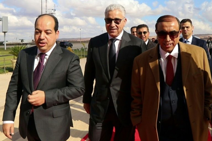 Libyan presidential candidates Ahmed Maiteeq (L) and Fathi Bashagha (C) arrive for a meeting with Libya's eastern military chief Khalifa Haftar, in the eastern city of Benghazi on December 21, 2021, a day before postponement of the election