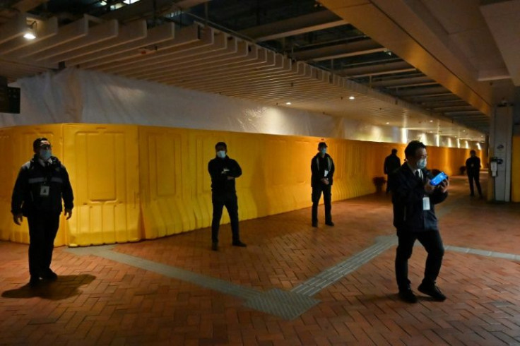 Security guards stand in front of barriers erected around the eight-metre (26-feet) high "Pillar of Shame" at Hong Kong University, which commemorates those killed in Beijing's Tiananmen Square in 1989