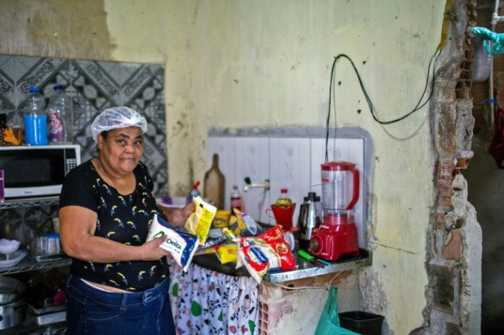 Rita Maria De Souza, 59, poses with her basic food parcel donated by the 'Acao da Cidadania' (Citizenship Action) NGO, during the 'Natal sem Fome' (Christmas without Hunger) event in Rio de Janeiro