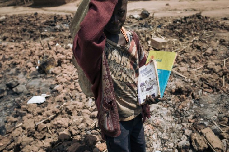 A child salvages school books from the Drodro camp for displaced people. The camp was devastated by militiamen last month