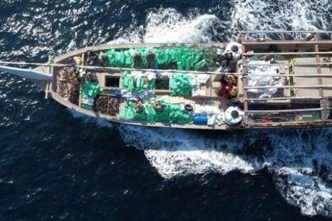 A handout photo taken on December 20, 2021 shows US service members from patrol coastal ship USS Typhoon check an illicit shipment of weapons while aboard a stateless fishing vessel transiting international waters in the North Arabian Sea