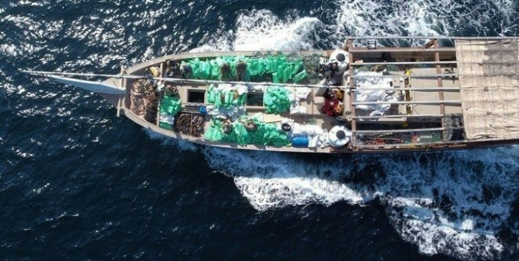 A handout photo taken on December 20, 2021 shows US service members from patrol coastal ship USS Typhoon check an illicit shipment of weapons while aboard a stateless fishing vessel transiting international waters in the North Arabian Sea