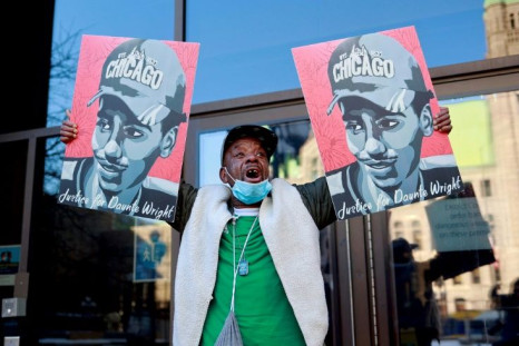 A demonstrator holds images of Daunte Wright outside the Hennepin County Government Center in Minneapolis, Minnesota, on December 23, 2021