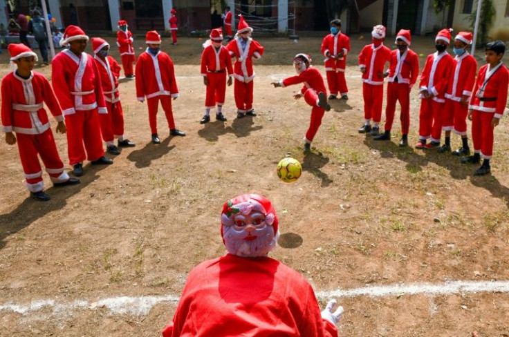 Children dressed as Santa Clause play with a soccer ball as they celebrate at their school ahead of Christmas in Chennai