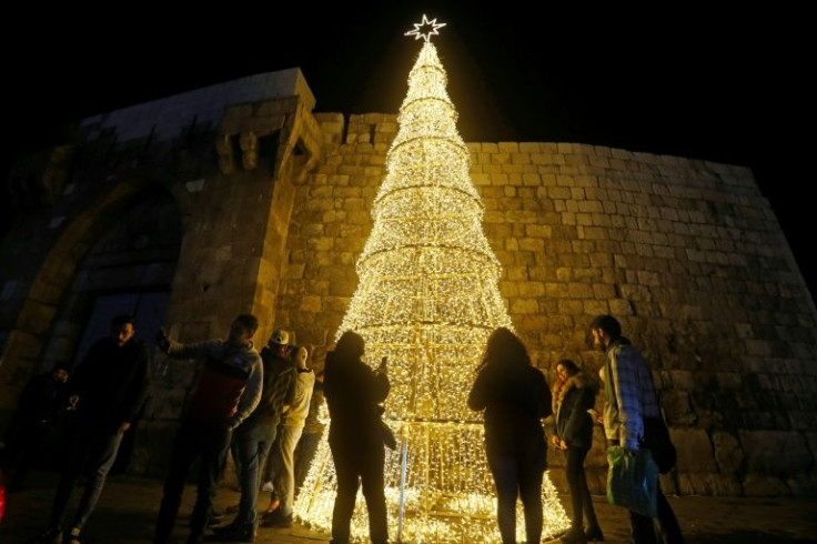 Syrians gather around a Christmas tree in the capital Damascus