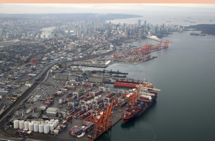 A container ship sits docked at the Port of Vancouver in November 2021 as dozens of ships wait in the harbour to pick up and unload shipments. A huge backlog was created when heavy rains and flooding destroyed road and rail links to the port