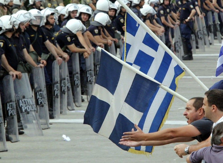 A demonstrator confronts riot police near the Greek parliament in Athens