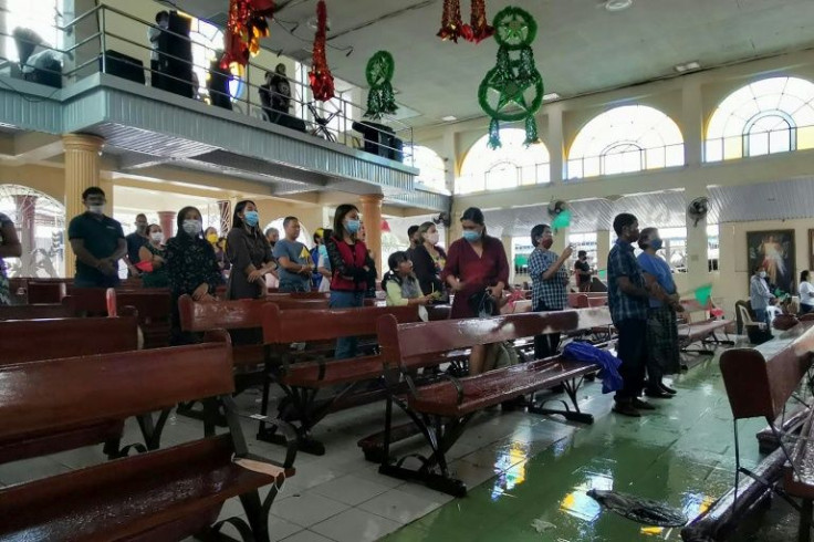 Devotees wear masks as they gather inside a church in Alegria, Surigao del Norte province, and pray for a better year