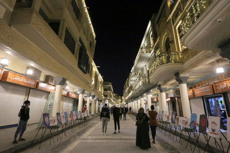People walk along the renovated Al-Mutanabbi Street, where in March 2007 a suicide car bomb killed 30 people and wounded 60 others