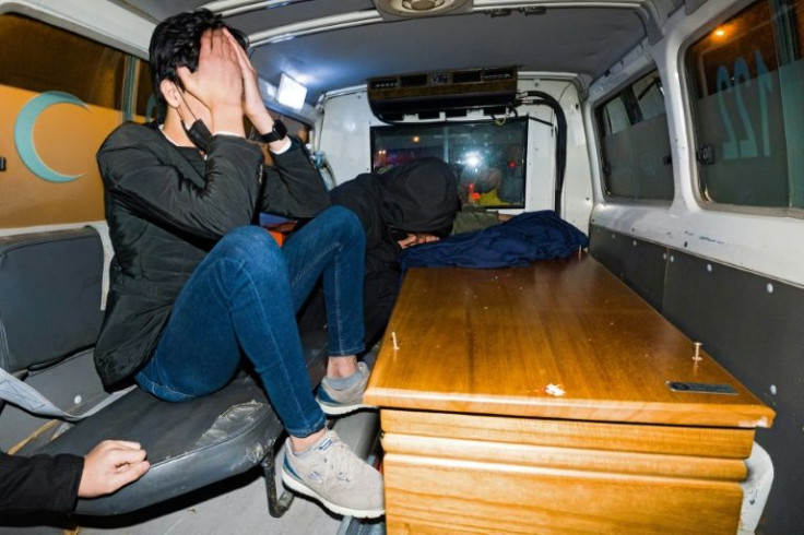 A Kurdish man mourns inside an ambulance carrying the remains of one of the 16 Kurds, killed when their boat sank in the Channel while trying to reach England, at the airport in Arbil, the capital of Iraq's autonomous Kurdish region