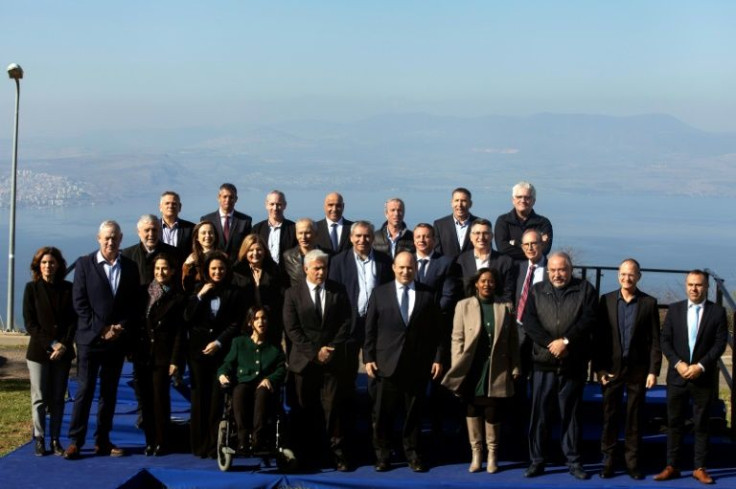 Israeli Prime Minister Naftali Bennett (C) poses for a photo with members of the government ahead of the weekly cabinet meeting which endorsed the plan that aims to build 7,300 new settler homes in the Golan Heights