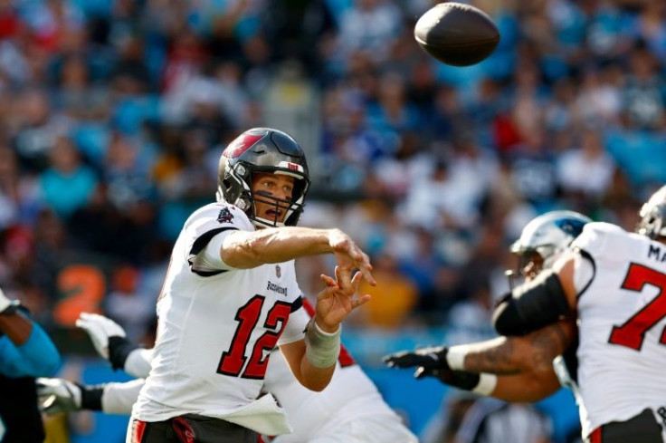 Tampa Bay quarterback Tom Brady sparked the Buccaneers over Carolina, clinching an NFL playoff berth for the reigning Super Bowl champions