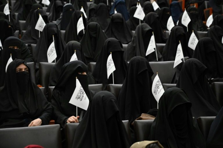 Veiled students hold Taliban flags at a lecture in a university in Kabul on September 11, 2021