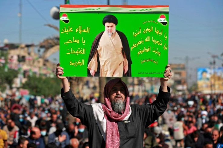 An Iraqi man holds a picture of Shiite cleric Moqtada Sadr, whose movement won a majority of seats in the legislature
