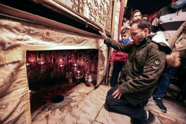 Ayyad kneels before the 14-pointed star marking the birthplace of Jesus, according to tradition, inside the Grotto at the Church of the Nativity