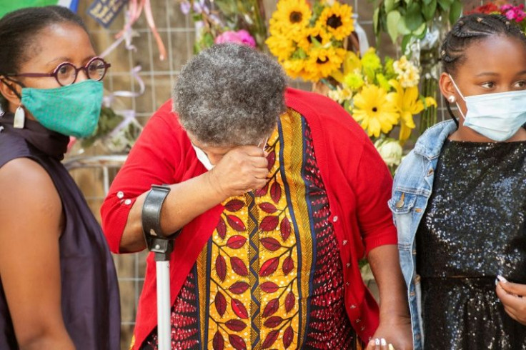 Grief: An elderly mourner her daughter and granddaughter at a Wall of Remembrance at St. George's Cathedral