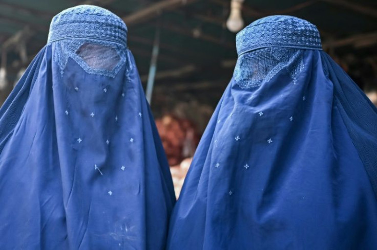 Afghan burqa-clad women at a market in Kabul on December 20, 2021