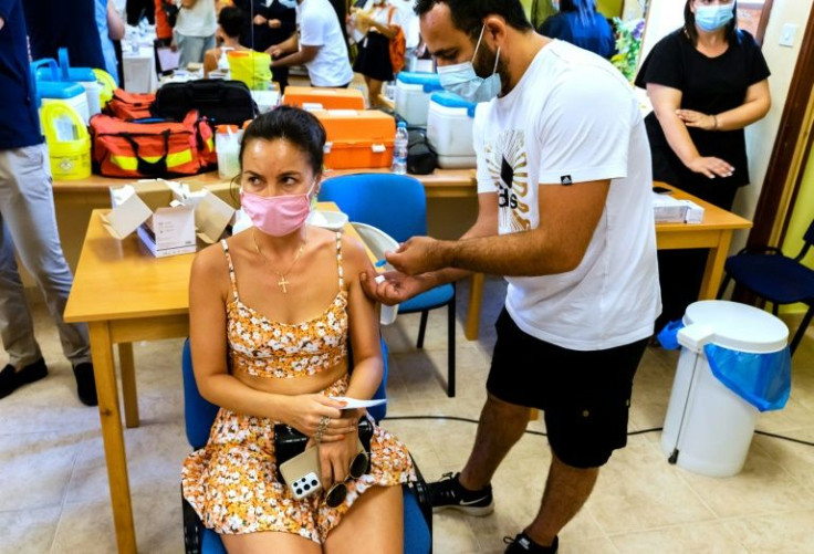 A woman receives a vaccination against the coronavirus at a walk-in centre for tourists, workers and locals in the Cypriot Mediterranean resort city of Ayia Napa on 29 July, 2021