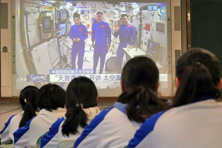 Students watch a live image of a lesson by Chinese astronauts from China's Tiangong space station, at a school  in Yantai in China's eastern Shandong province