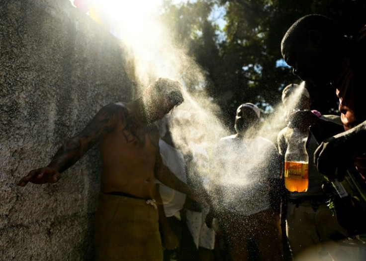 Abakua priest Ivanieski Quintana (right) cleanses Yosleny Luna in an oath ceremony
