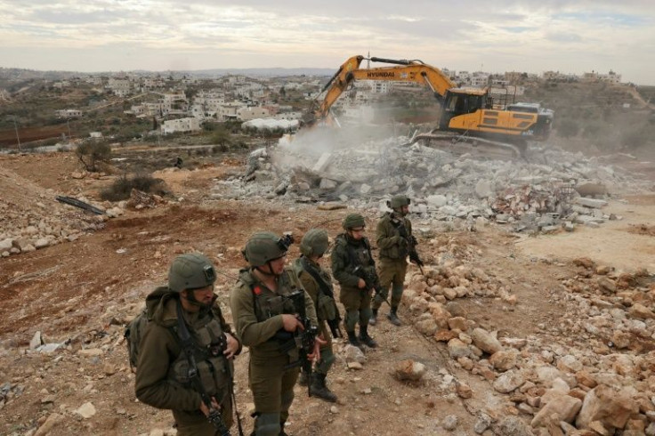 Israeli security forces stand guard during demolition of a Palestinian home, located within "Area C" of the occupied West Bank, where Israel retains full control over planning and construction, in the occupied West Bank town of Hebron on December 28, 2021