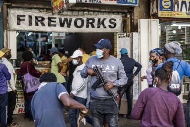 An undercover police officer is seen as customers queue to buy fireworks outside the St Mary Cathedral in Johannesburg ahead of New Years eve celebrations