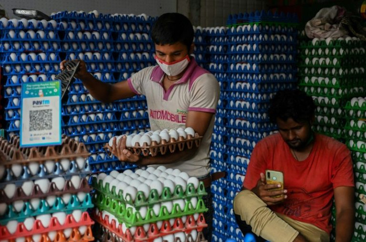 Workers at a poultry shop with a QR code for digital payment platform Paytm on display