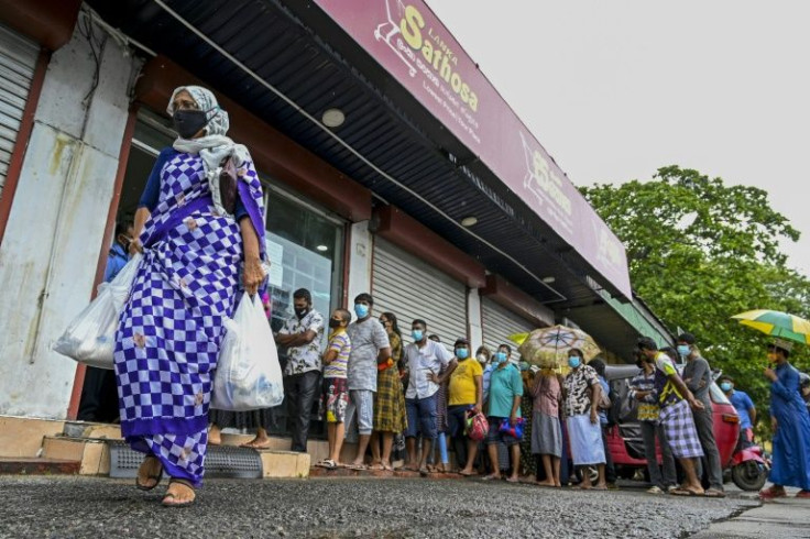 People queue outside a state-run supermarket to buy essentials in Colombo