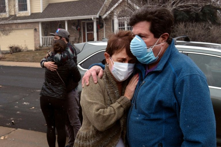 Louie Delaware embraces his wife Judy as his daughter Elise embraces her fiance McGregor Ritter after returning to the remains of their home in Louisville, Colorado on December, 31, 2021