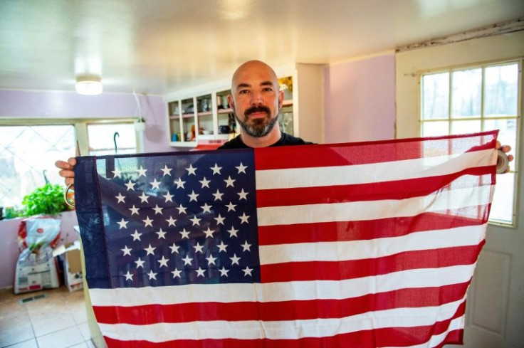 Samson Racioppi, 40, displays an American flag at his father's home in Salisbury,  Massachusetts