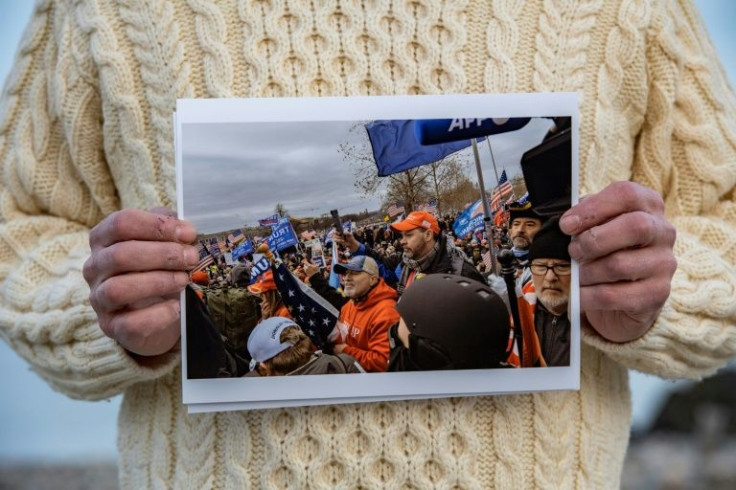 Glen Montfalcone holds a photo of himself outside the Capitol on January 6, 2021 -- he is in the center in the red hat