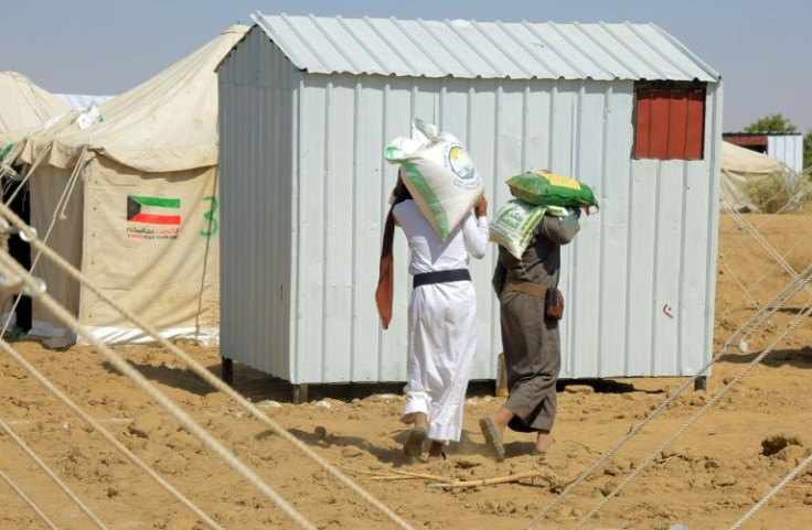 Displaced Yemenis return to their tents with aid donated by a Kuwaiti charitable organisation on the outskirts of Marib, the government's last northern stronghold